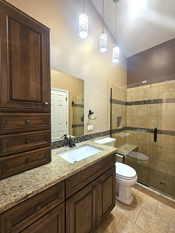 a bathroom with a granite countertop sink toilet and shower