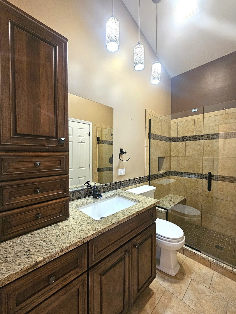 475 Bridle Trail Wheeling, IL 60090 - Photo 22 of 27 a bathroom with a granite countertop sink toilet and shower