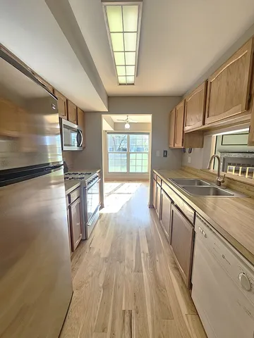 a view of a kitchen with a sink and wooden floor