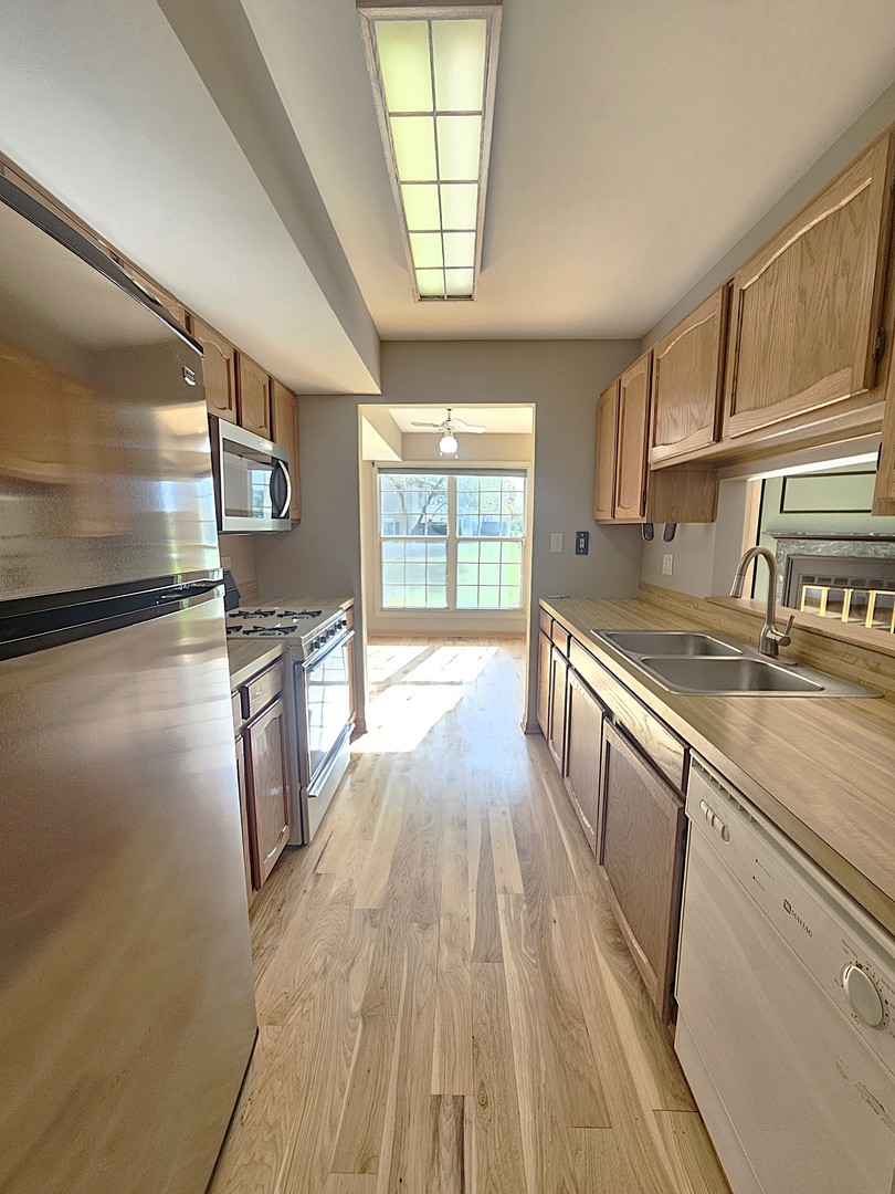 475 Bridle Trail Wheeling, IL 60090 - Photo 10 of 27 a view of a kitchen with a sink and wooden floor