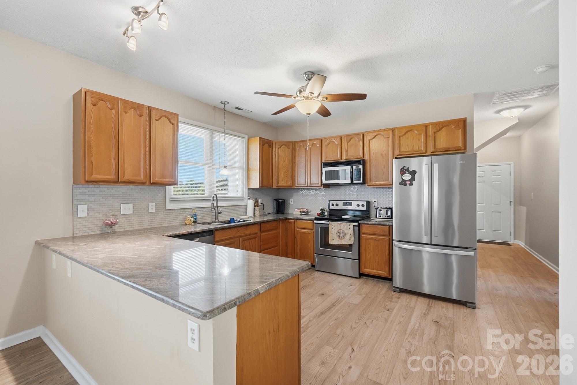 4415 Old Monroe Marshville Road Wingate, NC 28174 - Photo 8 of 28 a kitchen with stainless steel appliances granite countertop a refrigerator a sink dishwasher a stove with wooden cabinets and floor