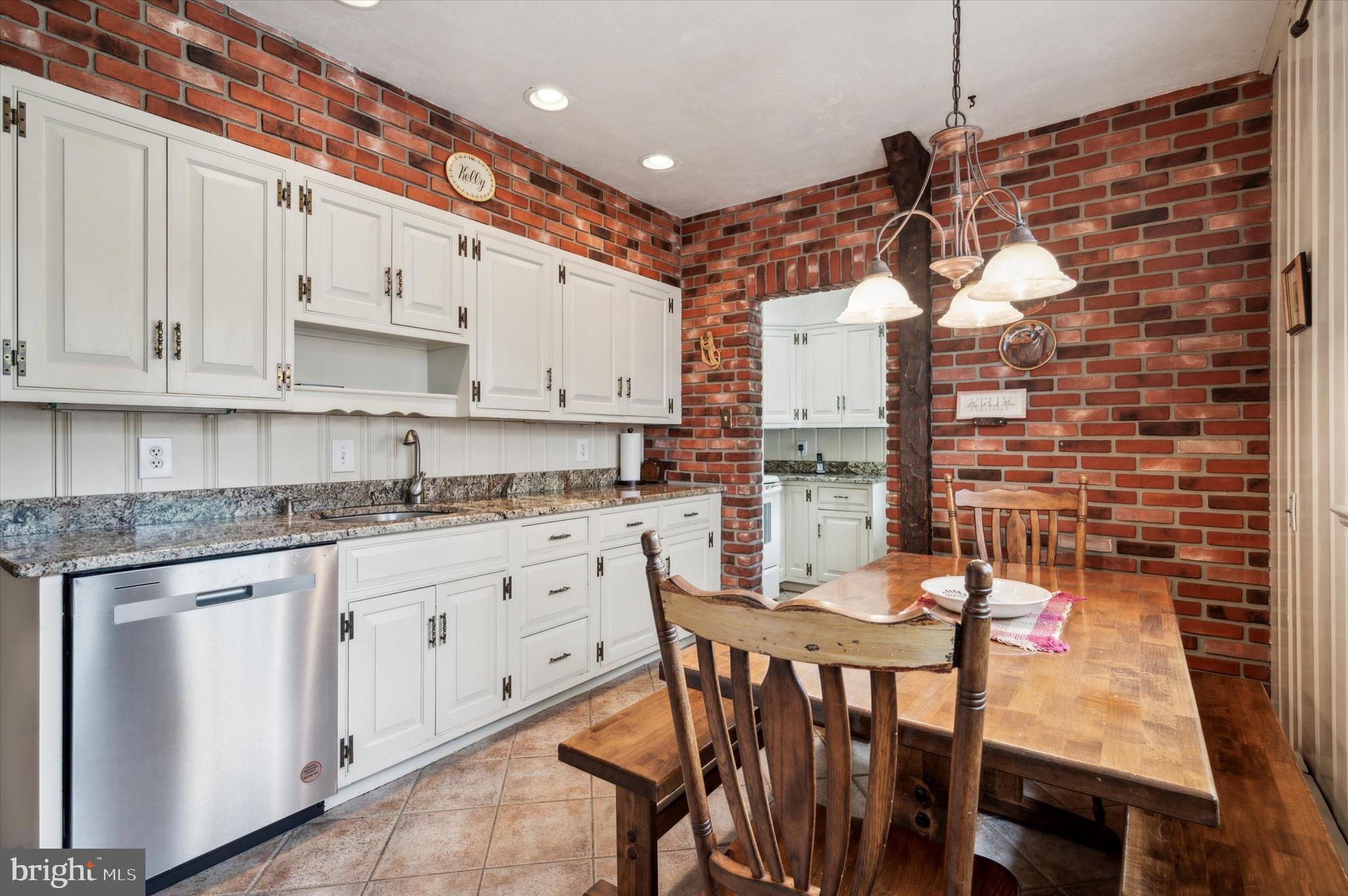 253 Sagamore Road Havertown, PA 19083 - Photo 13 of 25 a kitchen with stainless steel appliances granite countertop a stove a sink dishwasher and white cabinets with wooden floor