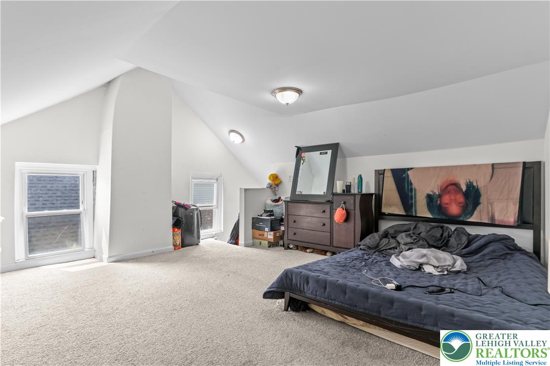 12 South Front Street Coplay, PA 18037 - Photo 32 of 41 This spacious bedroom offers ample natural light and plush carpeting, creating a comfortable living space.