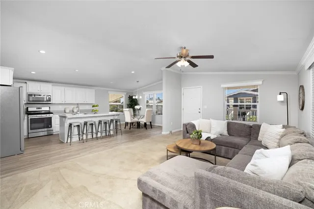 a living room with furniture a kitchen view and a refrigerator