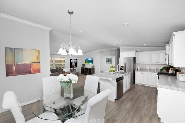 a dining room with furniture a chandelier and wooden floor