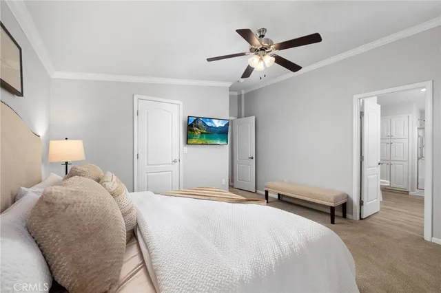 a bedroom with a large bed and a ceiling fan