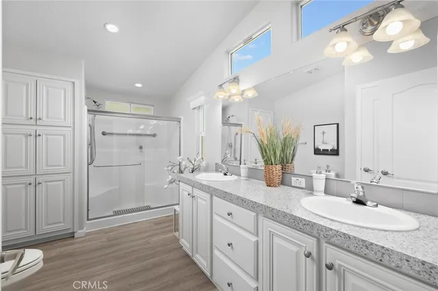 a spacious bathroom with a granite countertop sink a mirror and a shower