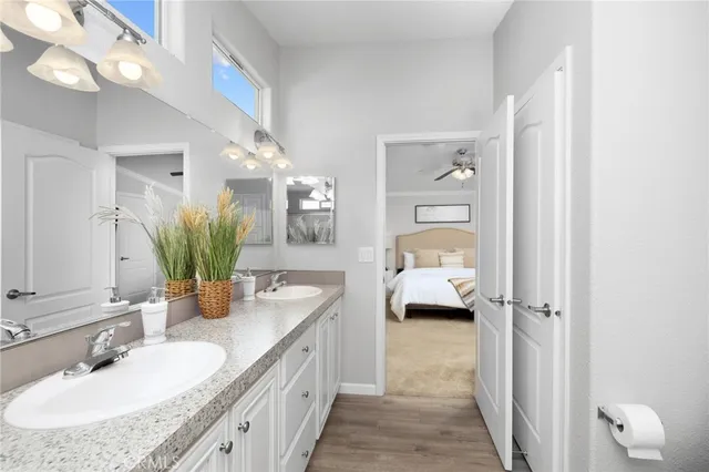 a en suite spacious bathroom with a granite countertop double vanity sink and a mirror