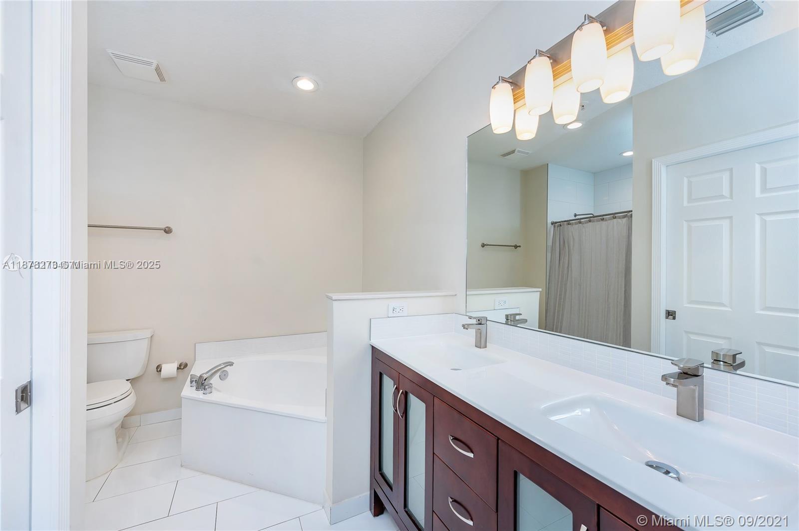 9021 Southwest 94th Street, Unit PH07 Miami, FL 33176 - Photo 12 of 32 a bathroom with a double vanity sink mirror and toilet