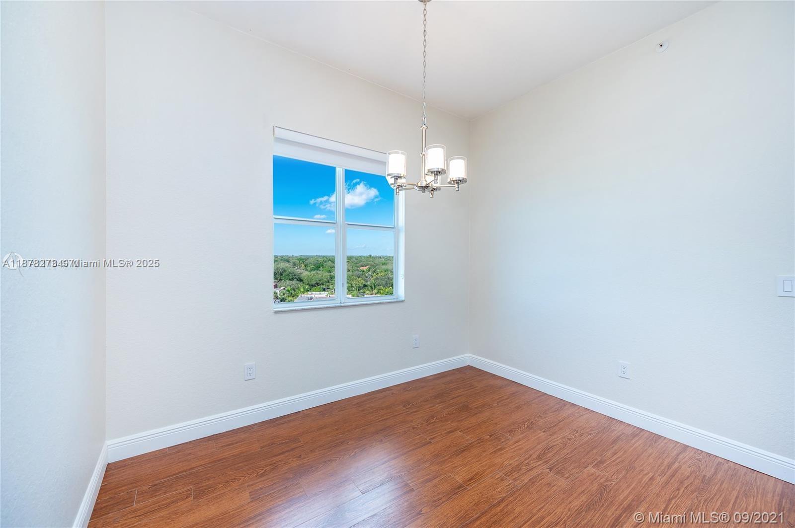 9021 Southwest 94th Street, Unit PH07 Miami, FL 33176 - Photo 17 of 32 an empty room with wooden floor and windows
