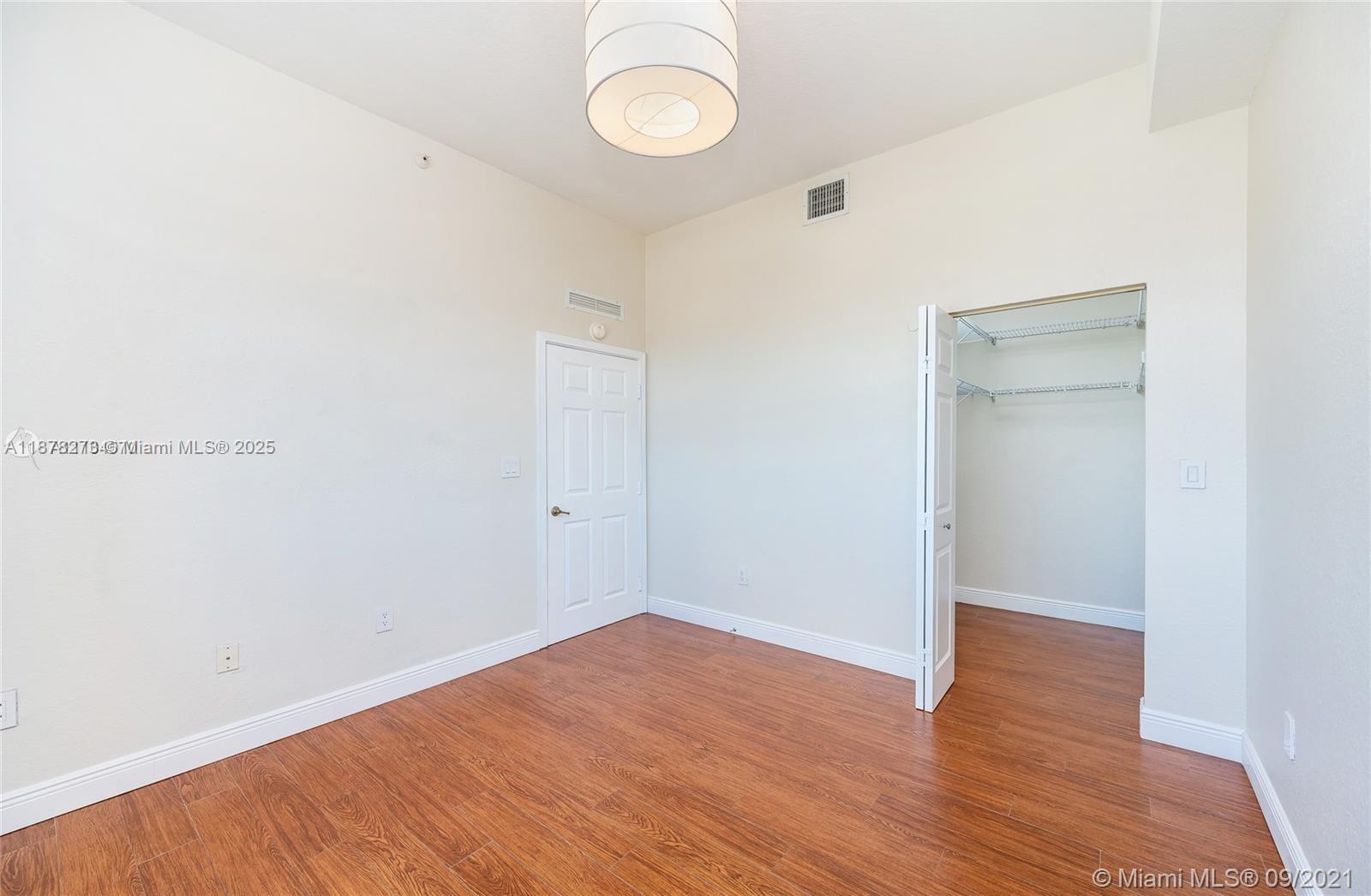 9021 Southwest 94th Street, Unit PH07 Miami, FL 33176 - Photo 19 of 32 a view of a room with wooden floor and white walls