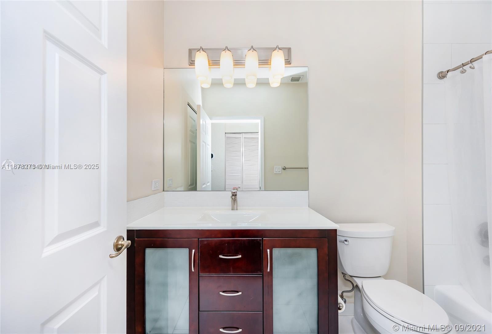 9021 Southwest 94th Street, Unit PH07 Miami, FL 33176 - Photo 22 of 32 a bathroom with a sink a toilet and mirror