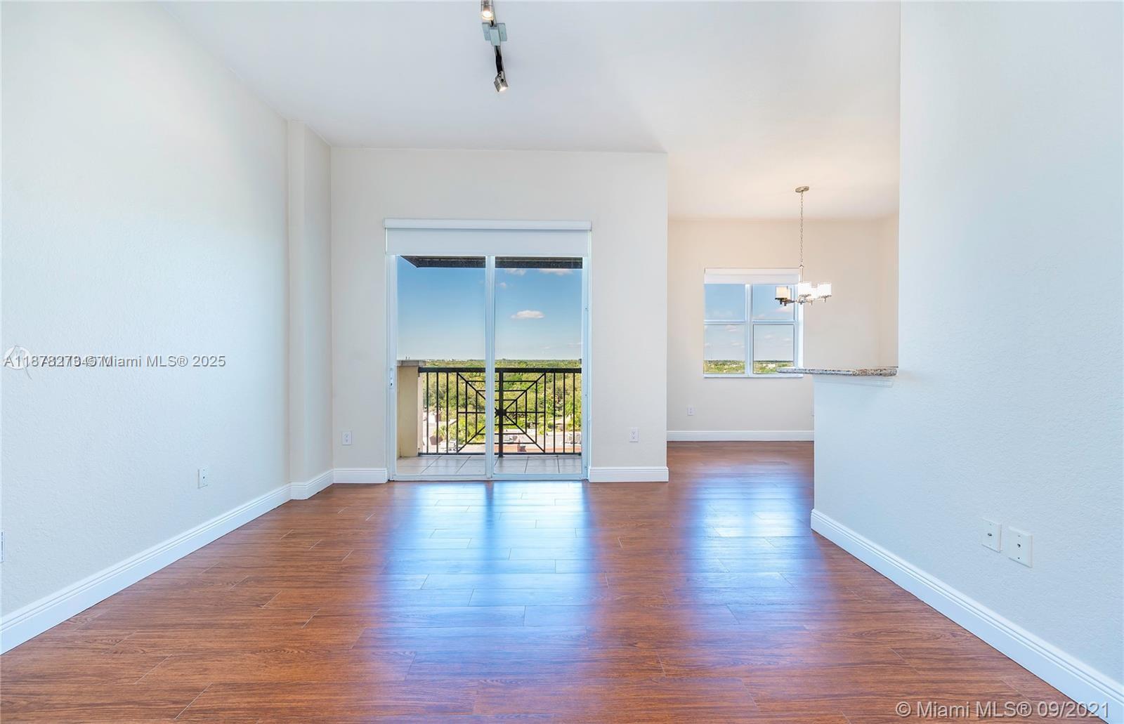 9021 Southwest 94th Street, Unit PH07 Miami, FL 33176 - Photo 3 of 32 a view of an empty room with wooden floor and a window