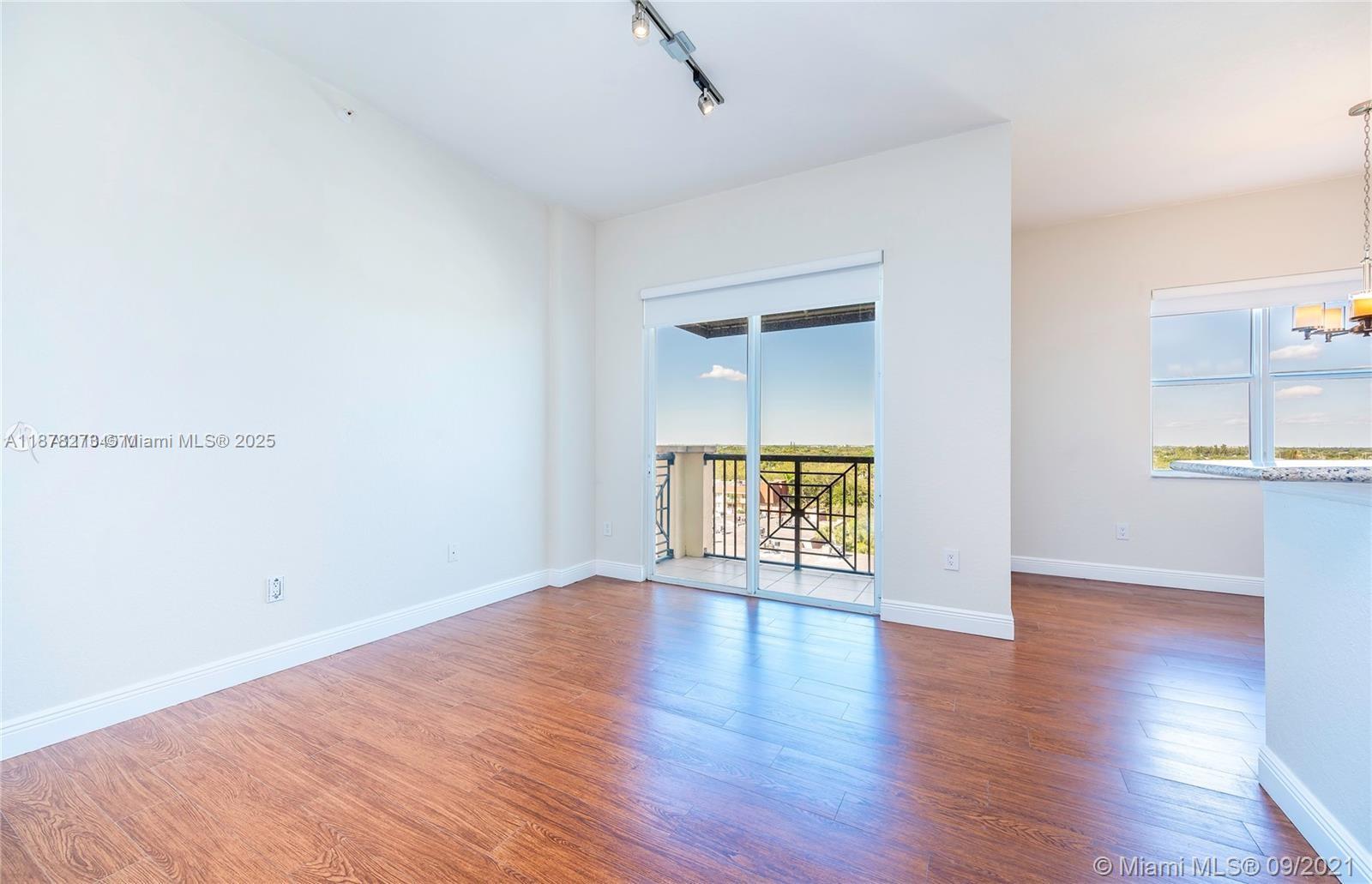 9021 Southwest 94th Street, Unit PH07 Miami, FL 33176 - Photo 5 of 32 a view of an empty room with wooden floor and a window