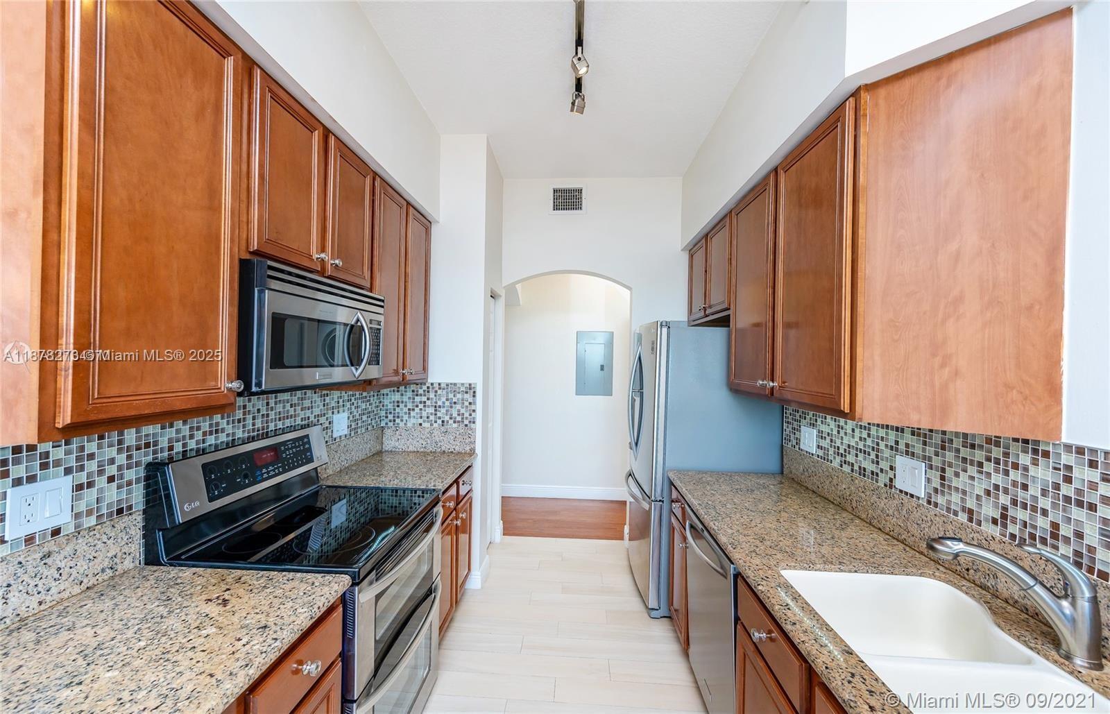 9021 Southwest 94th Street, Unit PH07 Miami, FL 33176 - Photo 7 of 32 a kitchen with granite countertop a stove sink and cabinets