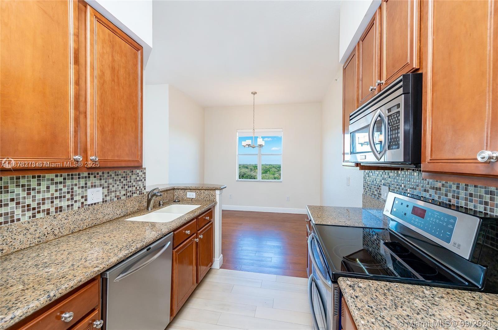 9021 Southwest 94th Street, Unit PH07 Miami, FL 33176 - Photo 8 of 32 a kitchen with a granite countertop sink stove and cabinets