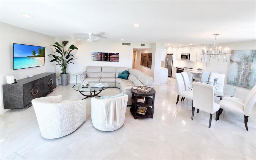 1050 Longboat Club Road, Unit 803 Longboat Key, FL 34228 - Photo 2 of 39 a living room with furniture a chandelier and a flat screen tv