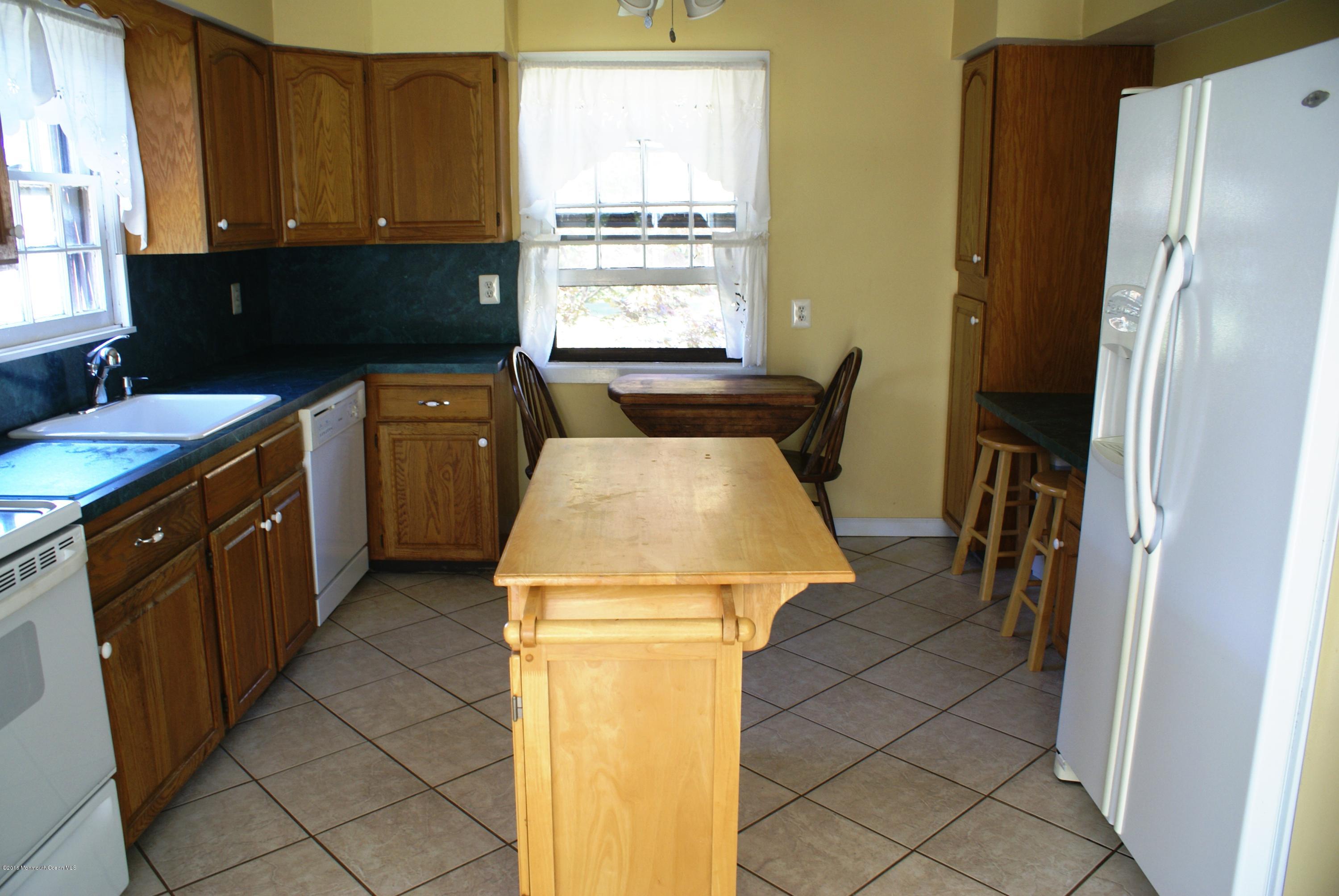 53 Tennent Road Morganville, NJ 07751 - Photo 3 of 11 a kitchen with a refrigerator and window