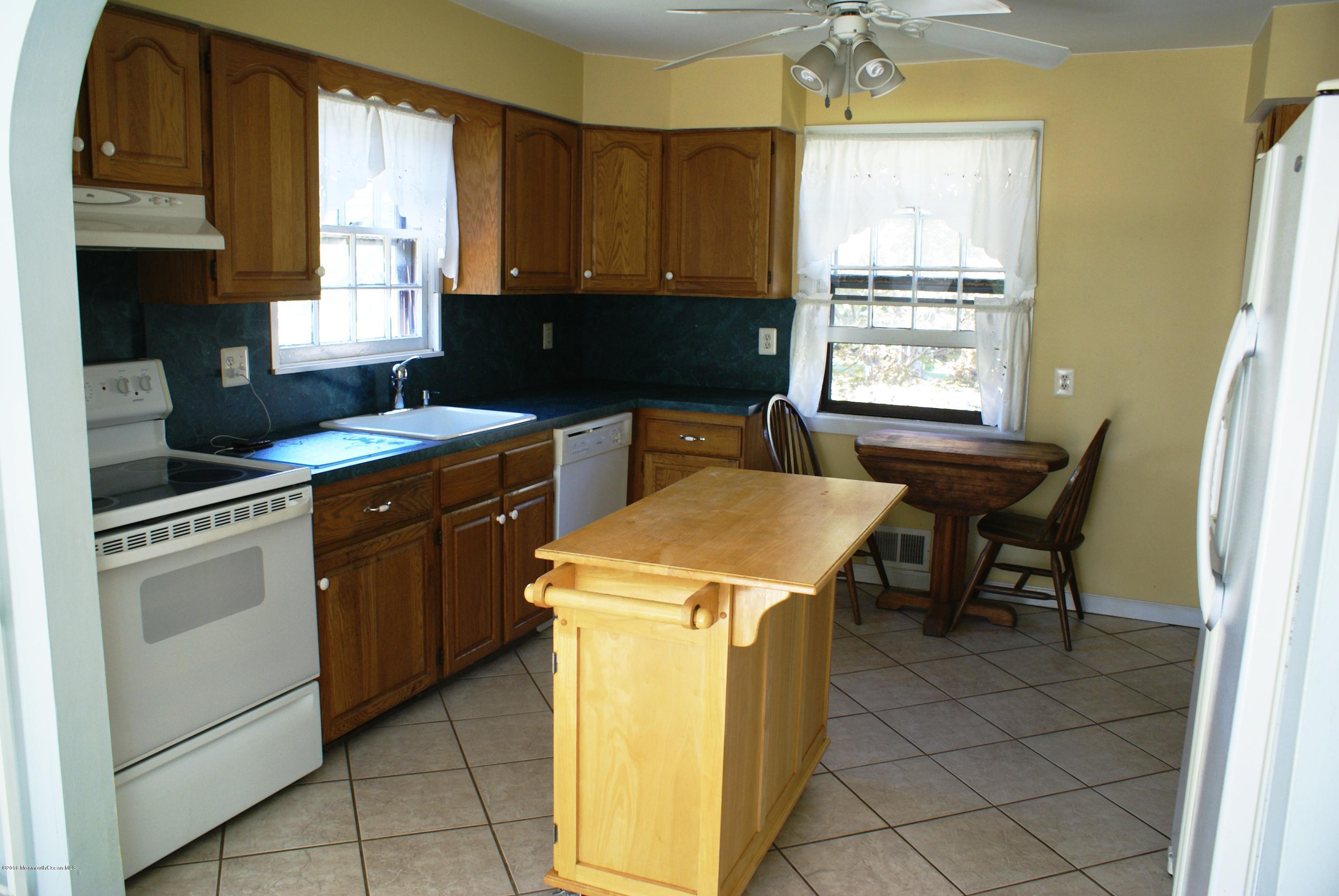 53 Tennent Road Morganville, NJ 07751 - Photo 4 of 11 a kitchen with a stove a sink a counter top space and cabinets