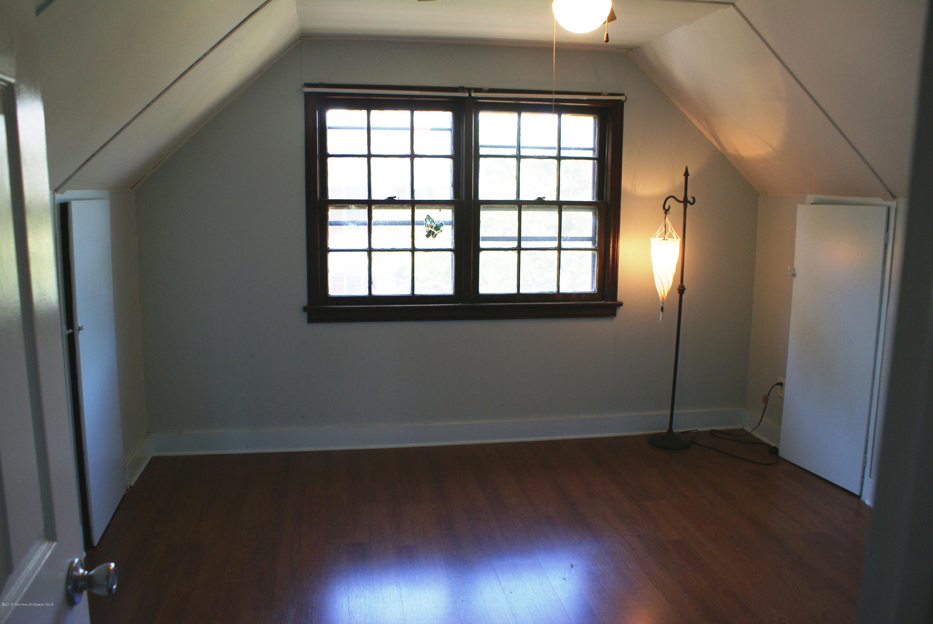 53 Tennent Road Morganville, NJ 07751 - Photo 8 of 11 an empty room with wooden floor and windows