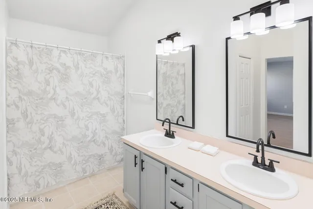 a bathroom with double vanity sink and a mirror