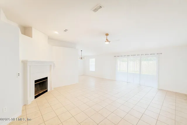 an empty room with windows and fireplace