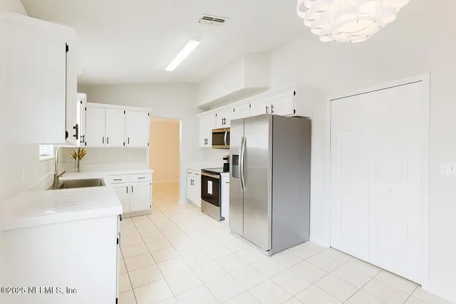 a kitchen with stainless steel appliances a refrigerator sink and cabinets