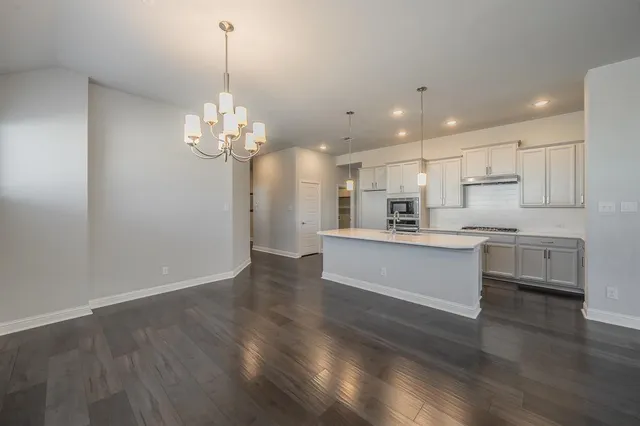 a kitchen that has a sink a counter space and wooden floor