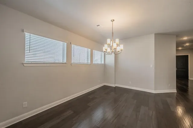 a kitchen with stainless steel appliances a stove top oven a sink a refrigerator white cabinets and wooden floor