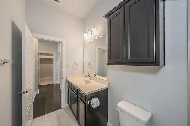 an empty room with a chandelier fan and windows