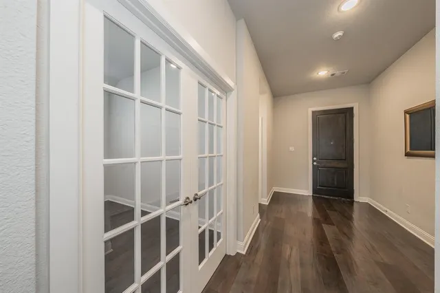 a view of a room with wooden floor and a ceiling fan