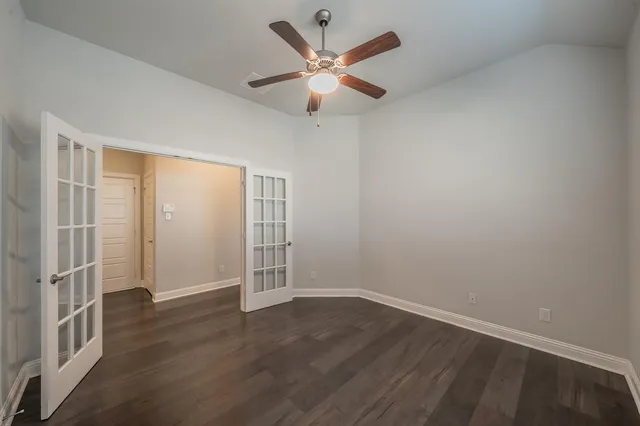 an empty room with a window and a fan