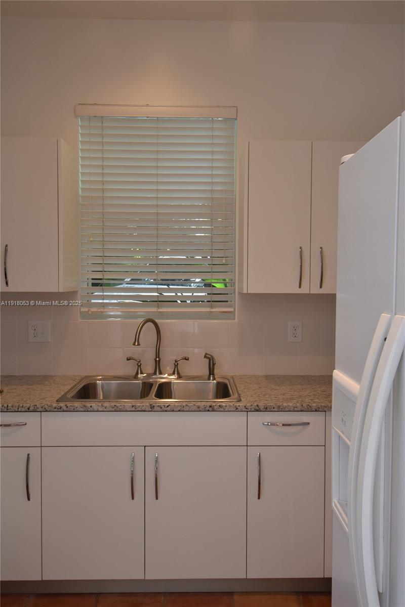 3051 Center Street, Unit 9 Miami, FL 33133 - Photo 8 of 11 a kitchen with granite countertop white cabinets and a sink