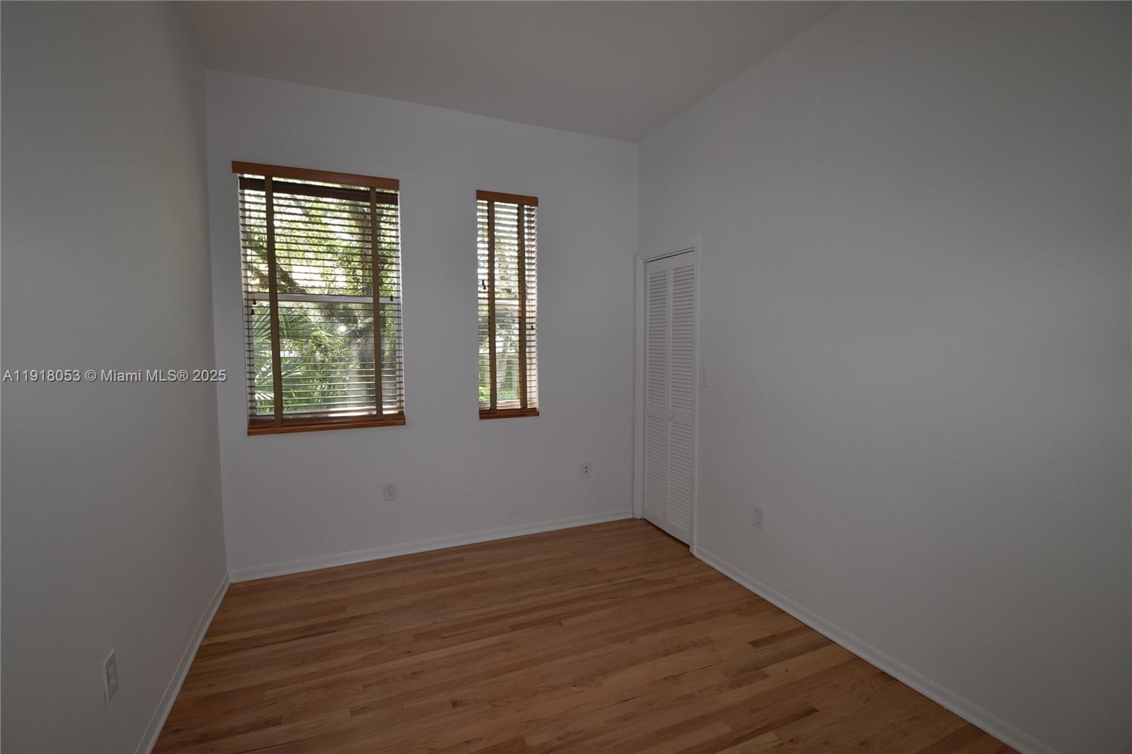 3051 Center Street, Unit 9 Miami, FL 33133 - Photo 9 of 11 an empty room with wooden floor and windows