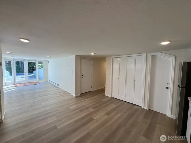 an empty room with wooden floor and windows