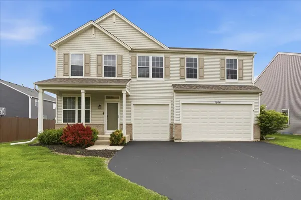 a front view of a house with a garden and garage