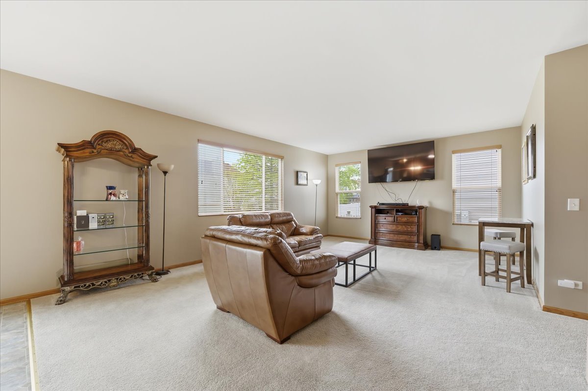 1916 Castle Ridge Drive Plainfield, IL 60586 - Photo 8 of 36 a living room with furniture a fireplace and a flat screen tv