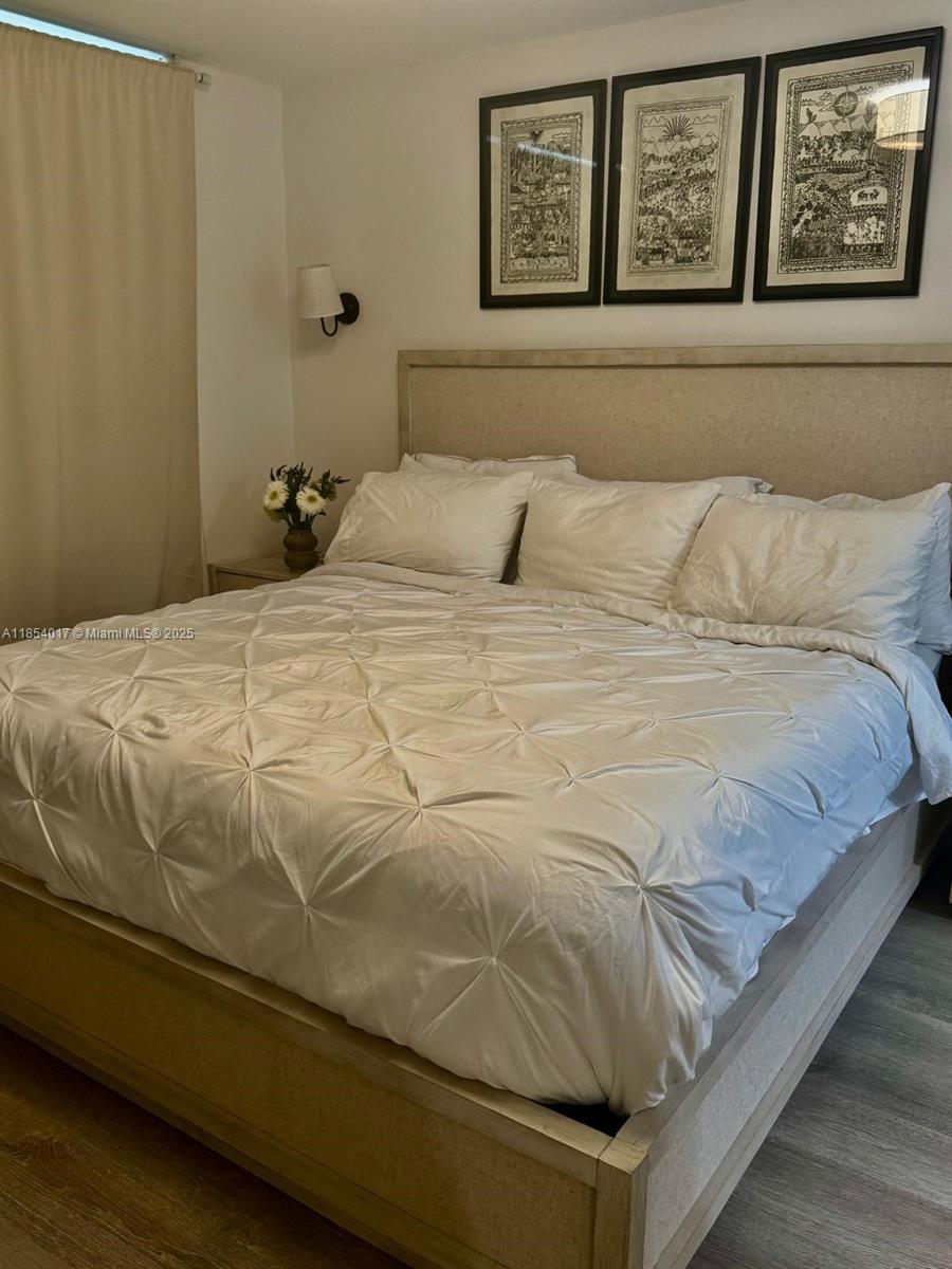 55 Ocean Ln Drive, Unit 1018 Key Biscayne, FL 33149 - Photo 19 of 36 a bedroom with a bed and painting on the wall