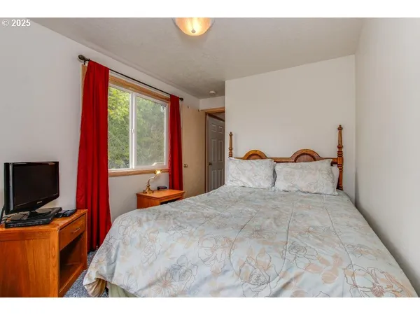 a bedroom with furniture and a flat screen tv