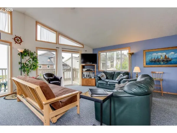 a living room with furniture a flat screen tv and a large window