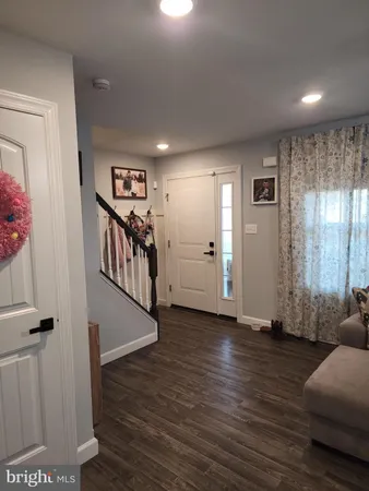 a view of a hallway with wooden floor and furniture