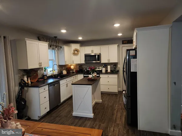 a kitchen with stainless steel appliances granite countertop a refrigerator stove microwave and sink