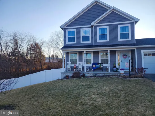 a front view of a house with table and chairs in patio