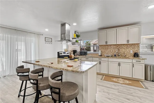 a kitchen with a dining table chairs sink and cabinets