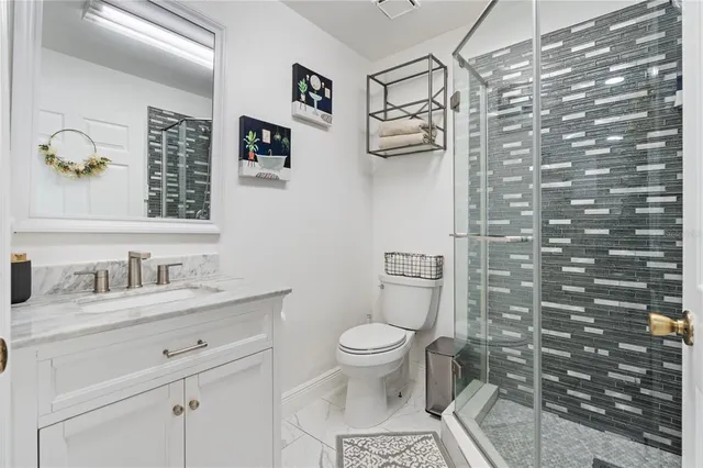 a bathroom with a granite countertop toilet sink and mirror