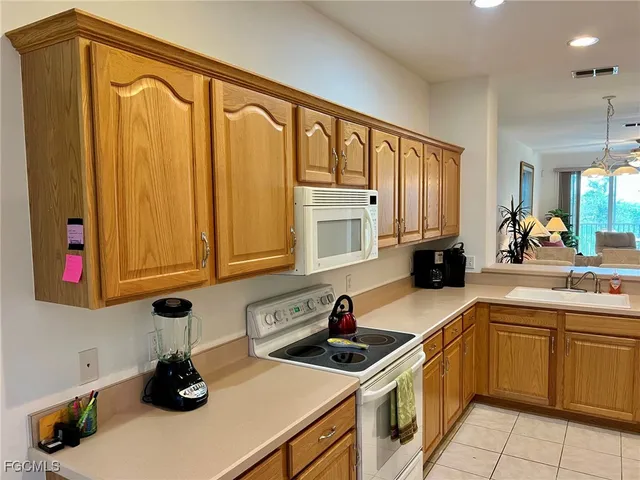 a kitchen with stainless steel appliances a sink dishwasher stove top oven and cabinets with wooden floor