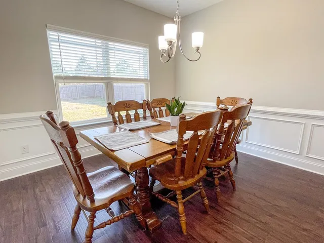 a view of a dining room with furniture a chandelier and wooden floor
