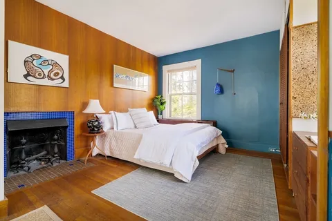 a living room with furniture a bookshelf and a window