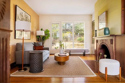 a living room with furniture a large window and a fireplace