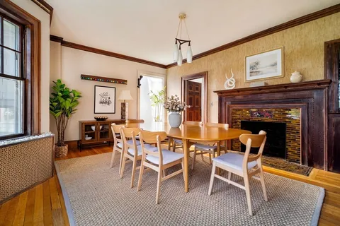 a view of a dining room with furniture a chandelier and wooden floor